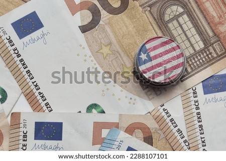 euro coin with national colorful flag of liberia on the euro money banknotes background