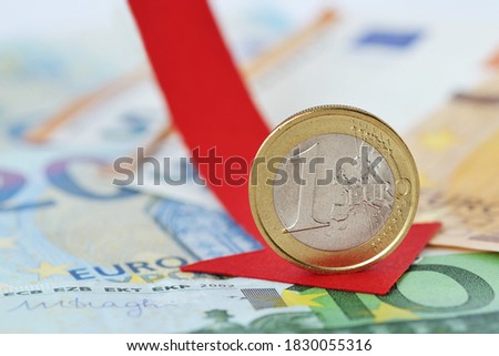 Euro coin with red decreasing arrow on euro banknotes - Concept of decrease in euro value and loss of money Foto stock © 