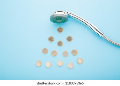 Euro coins as drops falling from shower head on light blue table background. Pastel color. Closeup. Water consumption and saving concept. - Shutterstock ID 2183895365