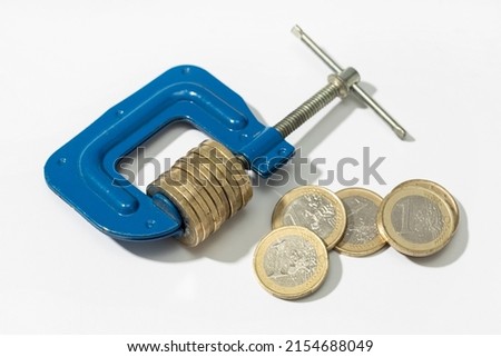 Euro Financial, money, tax pressure concept. Clamp clamping down of a group of euro coins on white background Foto stock © 