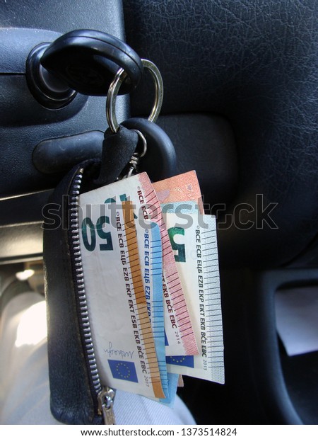 Euro money banknotes in black\
wallet with car ignition key close up                             \
