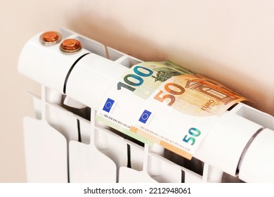 Euro Money Banknotes And Coins On Heating Radiator Battery. Concept Of Expensive Heating Costs And Rising Energy Bill Prices For Winter Cold Season In Europe. High Quality Horizontal Photo