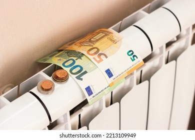 Euro Money Banknotes And Coins On Heating Radiator Battery. Concept Of Expensive Heating Costs And Rising Energy Bill Prices For Winter Cold Season In Europe. High Quality Horizontal Photo