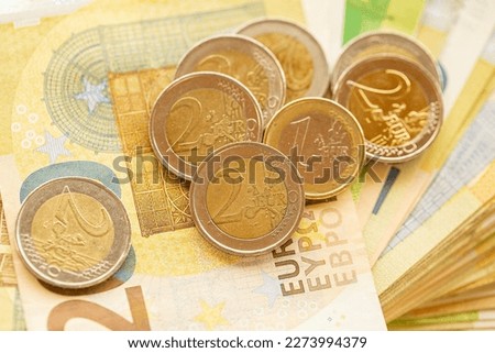 Euro money.Bundle of euro banknotes fan and column of coins.EU currency.Euro banknotes and euro coins close-up.Money and finance.