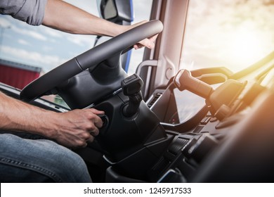 Euro Truck Driving. Modern Semi Truck Cabin Interior. Caucasian Trucker Placing Hand On A Steering Wheel. 