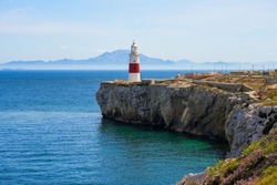 Europa Point Lighthouse Facing The Strait Of Gibraltar On Top Of Sea Cliffs With The Mountains Of Morocco On The Distance