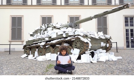 Europe, Italy, Milan April 2022  - Boy Child Protest Near A Military Tank Submerged By White Papers Against The War Between Russia And Ukraine In The Cathedral At Palazzo Reale - Culture Against War 