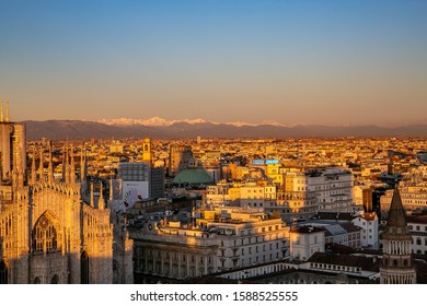 Europe, Italy , Milan December 14,2019 - Aerial Panoramic View Of The City Downtown, Duomo Cathedral And Skyline During The Sunset With Mountains 