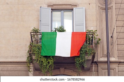  Europe, Italy , Milan - Flag of Italy hanging on the balcony of a house during n-cov19 Coronavirus epidemic emergency                              