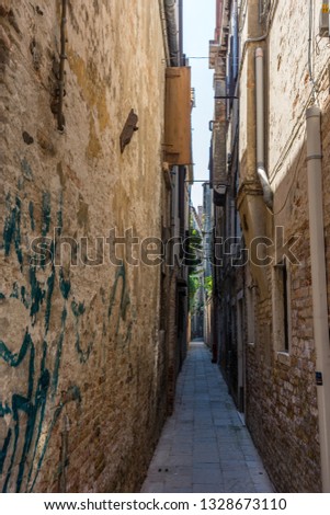 Europe, Italy, Venice, a narrow hallway with graffiti on the side of a building