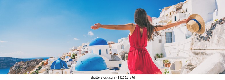 Europe travel vacation fun summer woman feeling free dancing with arms open in freedom at Oia, Santorini, Greece island. Carefree girl tourist banner panorama.