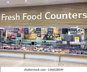 Europe UK Bedfordshire Bedford 21st March 2019. Major Supermarket. Fresh Meat And Grocery Food Customer Service Counter. Advertising Signage. Glass Fronted Display For Cheeses, Pies And Hams.