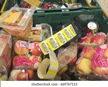 Europe UK Bedfordshire Bedford July 2017. Supermarket Food In Green Crates Ready To Be Reduced In Price. Roll Of Reduced Yellow Stickers With Bar Codes In Black Plastic Printing Machine.