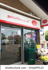 Europe UK Lincolnshire Alford May 2019. Glass Window Shop Front For Post Office. Small Grocery Store. Flowers And Shopping Baskets Outside. Advertising Signs. Security Camera.