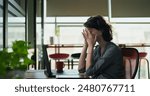 European angry tired woman sitting on chair use laptop talking shouting online video call indoor job office. Caucasian sad upset young adult female corporate distant quarrel feel head ache work place