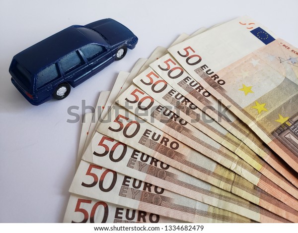 european\
banknotes and figure of a car in dark\
blue