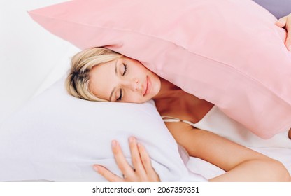 European Blonde Lying On A Bed With Pillows, A Silk Pillowcase.
