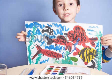 European boy demonstrates picture he has painted.