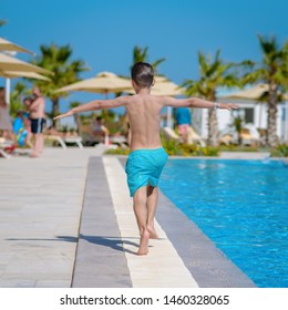 European Boy Running Along Swimming Pool. Back View.