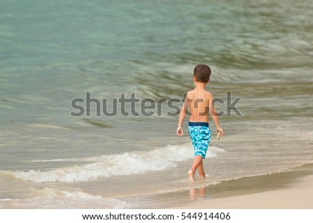 The European Boy Wearing Shorts is Walking for Relax and Holding a Coral Hand on Holiday at  Nai Yang Sea Beach Phuket, Thailand Set as Blank Frame for Text