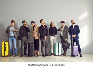 European business people in suits with bags and suitcases line up while standing inside the airport and waiting their turn to go to the check-in counters or boarding gate. Travelling by plane concept - Powered by Shutterstock