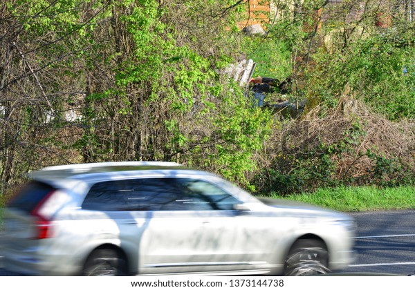 european cars passing by with green landscape\
in the background