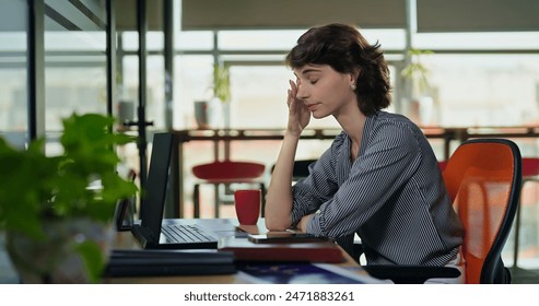 European Caucasian business woman sitting chair feel tired lack of energy indoor job office work place. Young adult gen z exhausted lazy bored female worker lady employee use laptop do over hours work - Powered by Shutterstock