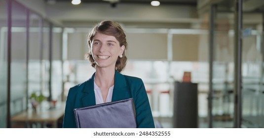 European Caucasian happy look confident empower business woman hold document file standing indoor job office place. Young adult smiling proud professional female going to work enjoy corporate career - Powered by Shutterstock