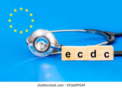 European Centre for Disease Prevention and Control (ECDC) text on wooden block with stesthoscope and EU star logo on blue background. - Shutterstock ID 1916699549
