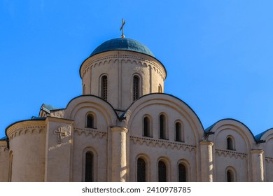 It is an European christian church. It is  close up view of church in sunny  midday. There is golden cross on church dome.