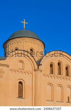 It is European christian church. It is  close up view of church in sunny  midday. There is a golden cross on church dome.