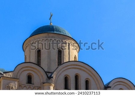 It is European christian church. It is  close up view of a church in sunny  midday. There is golden cross on church dome.