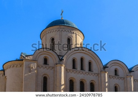 It is an European christian church. It is  close up view of church in sunny  midday. There is golden cross on church dome.
