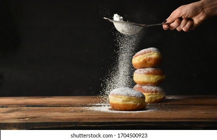 European donut sprinkled with powdered sugar on black background - Powered by Shutterstock