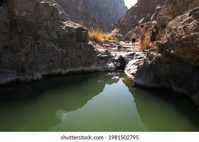 A European Family Exploring The Wadi In The Outskirts Of UAE.