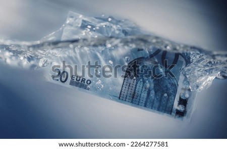 European financial crisis concept. Euro banknote sinking in water. Close up.
