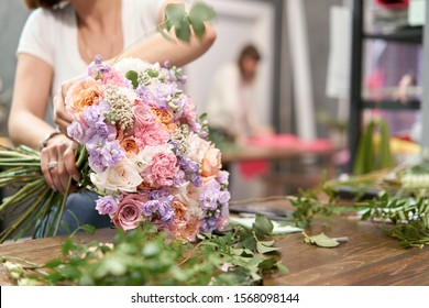 European floral shop concept. Florist woman creates beautiful bouquet of mixed flowers. Handsome fresh bunch. Education, master class and floristry courses. Flowers delivery. - Shutterstock ID 1568098144