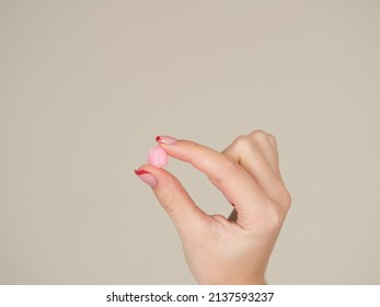 European Girl Getting Ready For Bed. Pink Earplug In A Female Hand Close-up. Peace And Quiet Throughout The Night. Healthy Lifestyle.