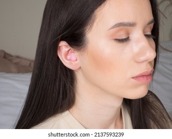 European Girl Getting Ready For Bed. Earplugs In The Ear Will Provide Peace And Quiet All Night Long.