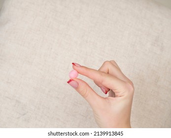 European Girl Getting Ready For Bed. Pink Earplug In A Female Hand Close-up. Peace And Quiet Throughout The Night. Healthy Lifestyle.