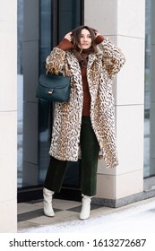 European Girl In A Leopard Coat, Corduroy Pants With A Handbag Walks On The Street. Life Style