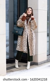 European Girl In A Leopard Coat, Corduroy Pants With A Handbag Walks On The Street. Life Style