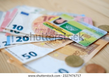 European health insurance card, 20, 50 euro banknotes, Insurance cheaper in German, concept medical support on trip to Europe, guarantee of treatment, healthcare coverage, payments to medical fund