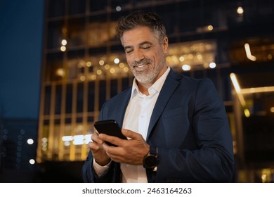 European latin middle age male entrepreneur businessman working on mobile cell phone. Confident mature hispanic senior business man holding smartphone cellphone, using app at busy street at evening - Powered by Shutterstock