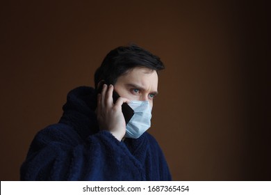 European Man With Dark Hair Holding Cell Phone Calling A Doctor. Man On Quarantine Calls On Coronavirus Or Covid 19 Hotline.