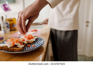 European Man Making Sandwich With Cheese In Kitchen At Home