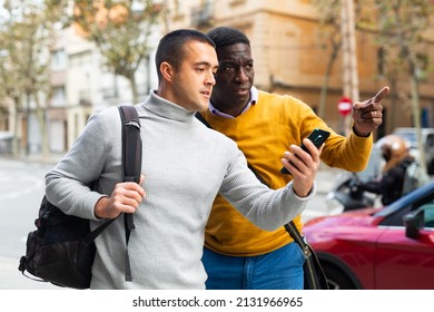 European man with smartphone having conversation with African-american man about directions. - Shutterstock ID 2131966965