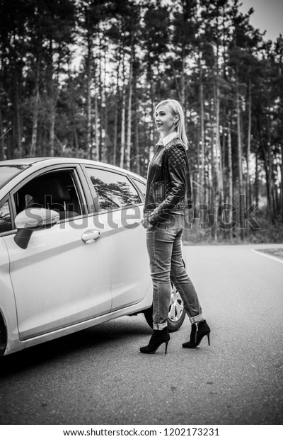 European mature\
elegant woman and car, lady driving automobile, outdoors portrait.\
Middle age woman driving on road, trip on beautiful autumn day.\
Concept of women and\
auto