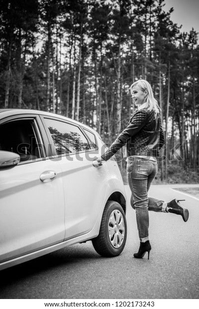European mature\
elegant woman and car, lady driving automobile, outdoors portrait.\
Middle age woman driving on road, trip on beautiful autumn day.\
Concept of women and\
auto