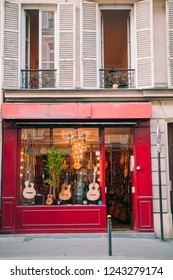 A European Music Store On The Streets Of Paris In France During A Pandemic. No People During Quarantine. Acoustic Guitars On Display.